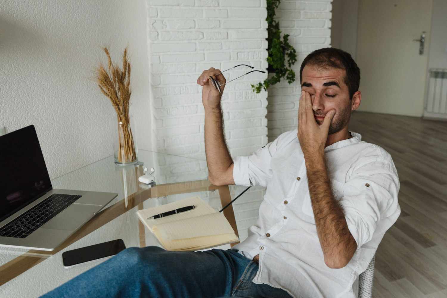 Professional experiencing digital eye strain while working on a laptop for long hours.